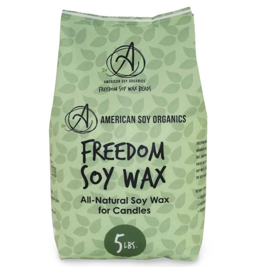 A green bag of American Soy Organics Freedom Soy Wax, perfect for crafting candles with dried flowers. The bag features black text declaring it's all-natural soy wax for candles and weighs 5 pounds. The design includes a logo and leaf patterns in the background.